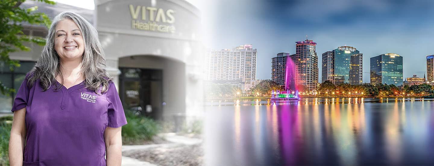 Una miembro del equipo de VITAS sonríe a la izquierda con la silueta de la ciudad de Orlando a la derecha