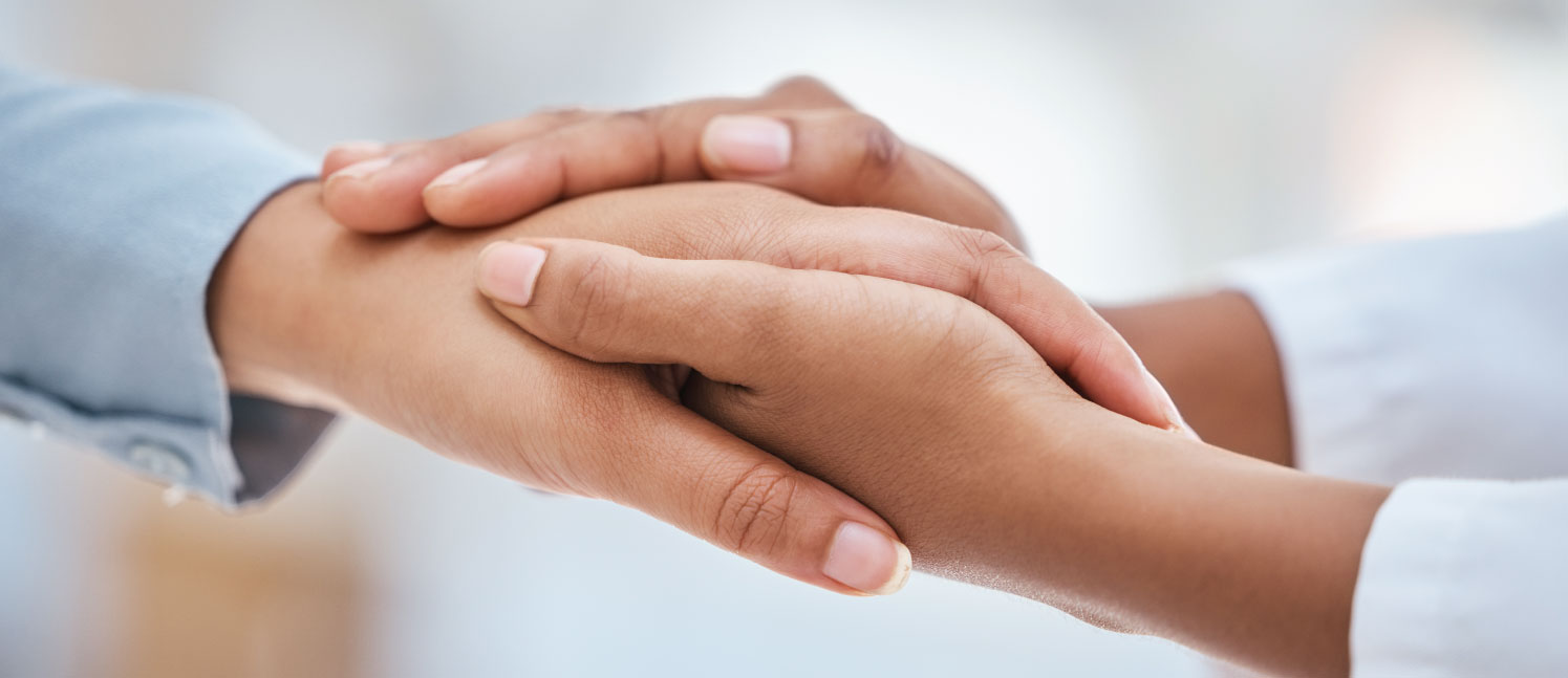 One person's hand holding another person's hand