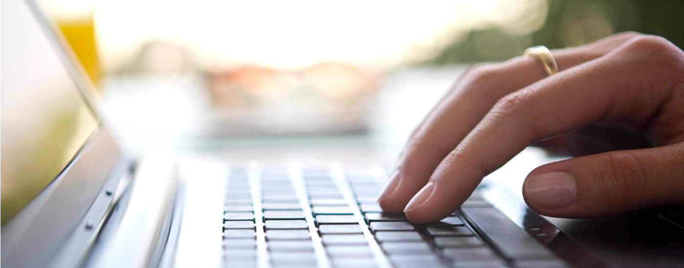 A closeup of a person typing on a laptop keyboard