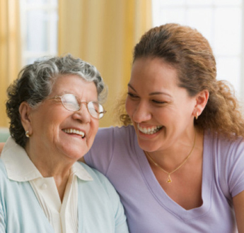 Una mujer de edad avanzada y una mujer más joven se sonríen una a otra