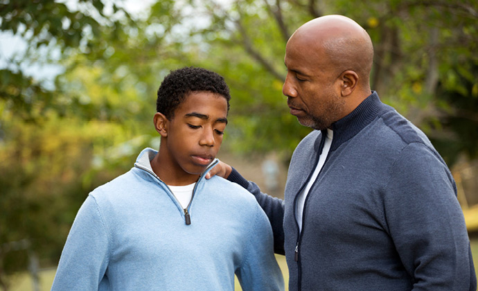 Un hombre habla con su hijo adolescente