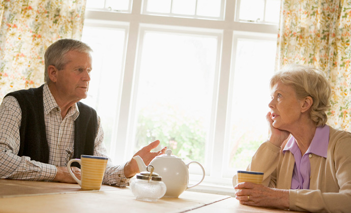 Una pareja habla mientras toman una taza de té en la mesa de la cocina