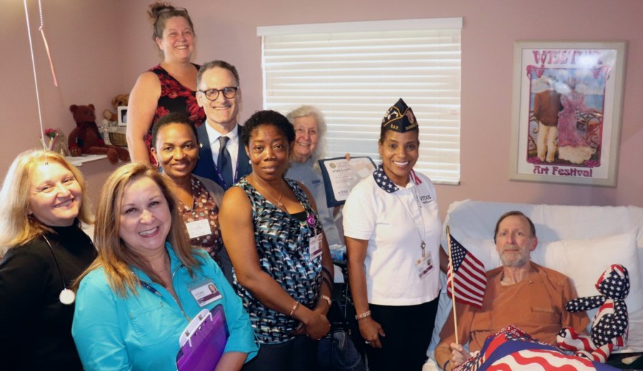 The group poses with U.S. Army veteran Daniel "Danny" Kessler in his room