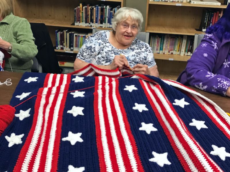 Volunteer Jane Polly works on a star-spangled blanket