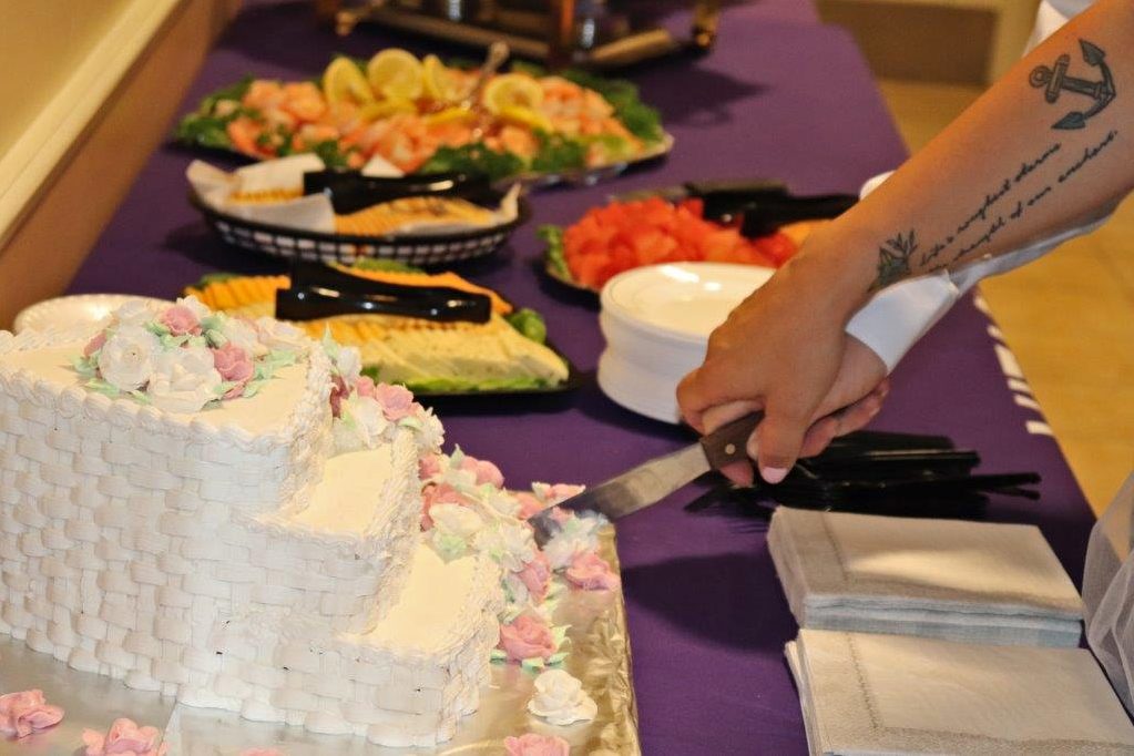 The three-tiered white wedding cake decorated with white and pink buttercream roses