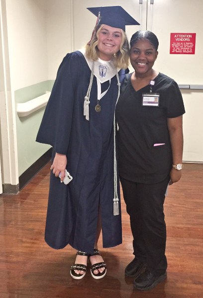 April wears her cap and gown to pose for a photo with Kennedy