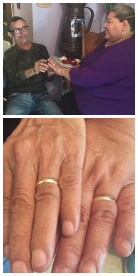 The couple places rings on each other's hands (above), and show off their wedding bands (below)