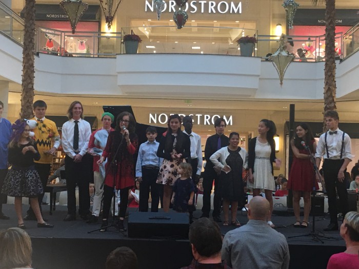 A group of young people on stage at the mall
