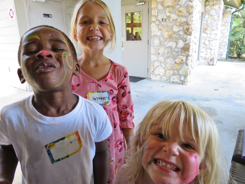 Three children smile at the camera