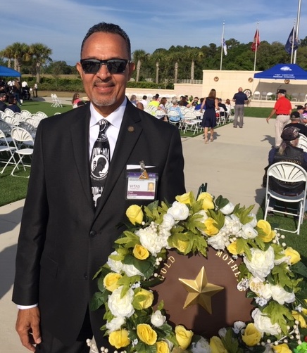 Fred Robinson stands next to a commemorative wreath