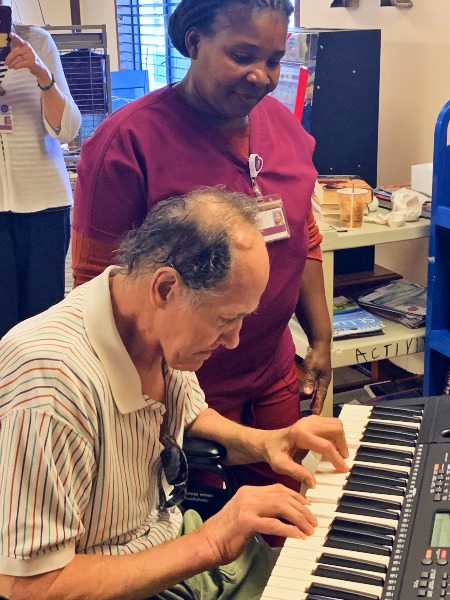 David plays his keyboard as a member of his VITAS hospice care team looks on