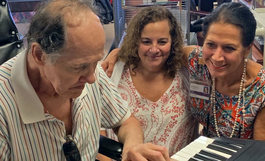 David plays the keyboard as two members of his care team look on