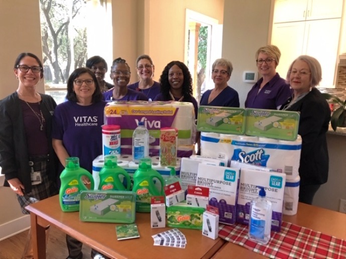The team with items they donated, including essentials like laundry detergent, paper towels, toilet paper and Swiffer sweepers