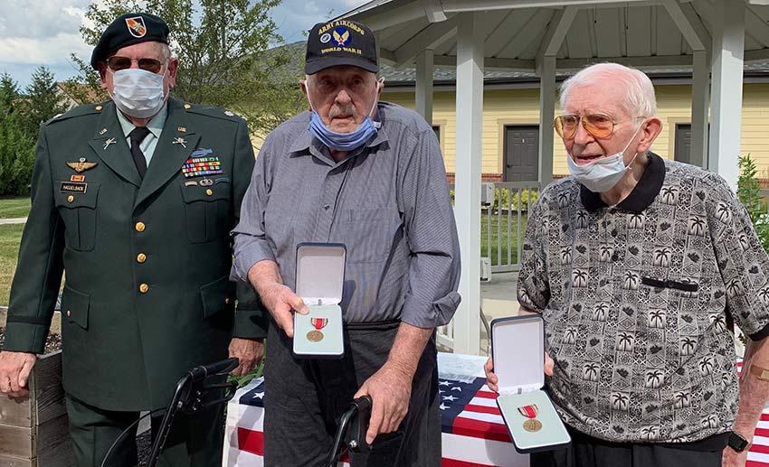 Dehlin and Fuller hold their medals as Hasselback looks on