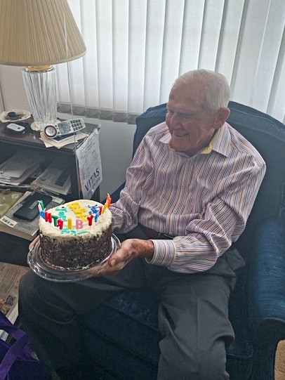 Jerry holds his birthday cake, complete with candles that spell out Happy Birthday