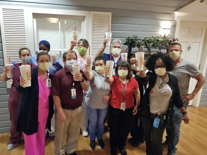 The staff at The Town Square, Steward assisted living facility hold up smoothies provided by VITAS