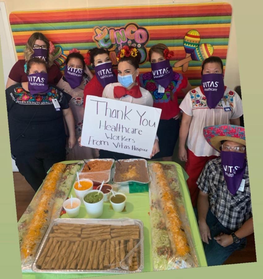The team surrounds the table of Mexican food provided for Cinco de Mayo