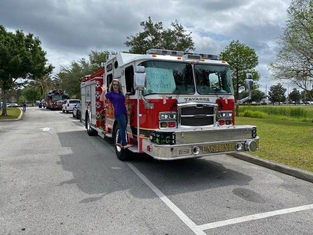 A VITAS team member with a fire truck for the parade
