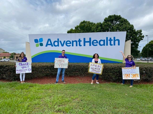 Four VITAS team members hold signs showing their gratitude for healthcare workers and first responders
