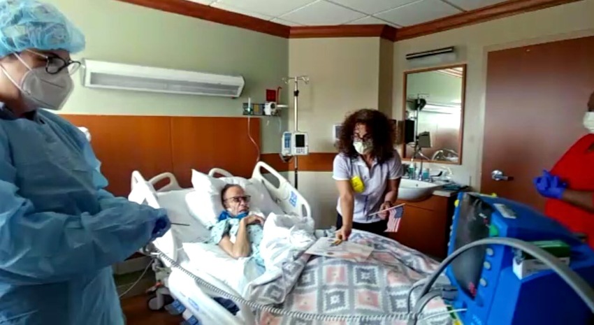 VITAS team members surround Joseph Delerme's bed for a bedside salute