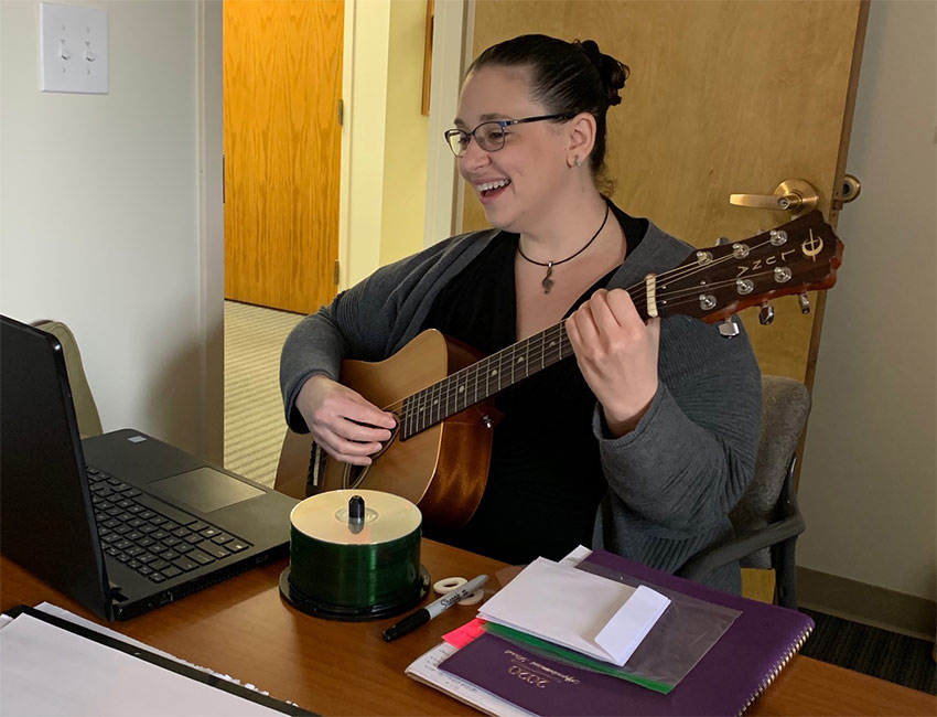 Cheryl Lynn Olson plays guitar and records music at a laptop