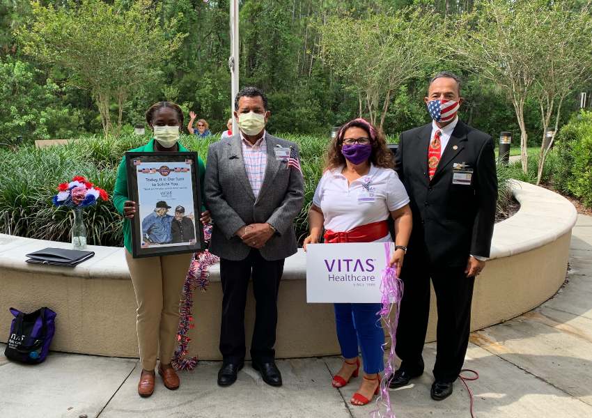 VITAS team members stand outside with materials honoring veterans