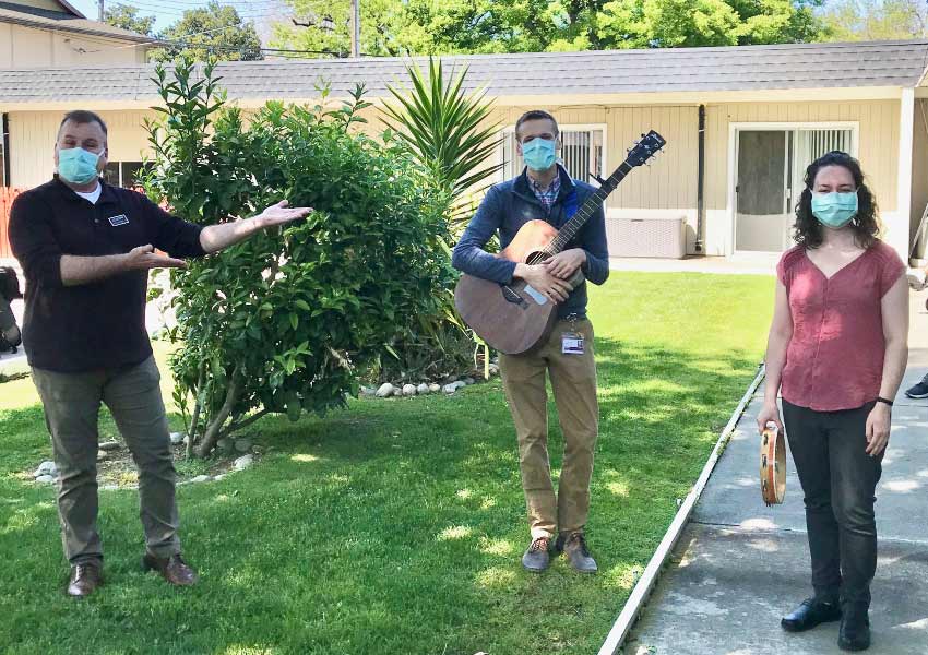 Brad Steiger and Rebekah Steiner, wearing masks, in the courtyard at a local healthcare facility
