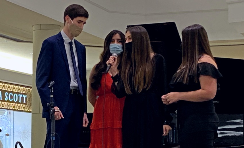 Four vocalists perform while wearing masks for safety