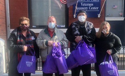 The group poses with the care packages outside Joseph House