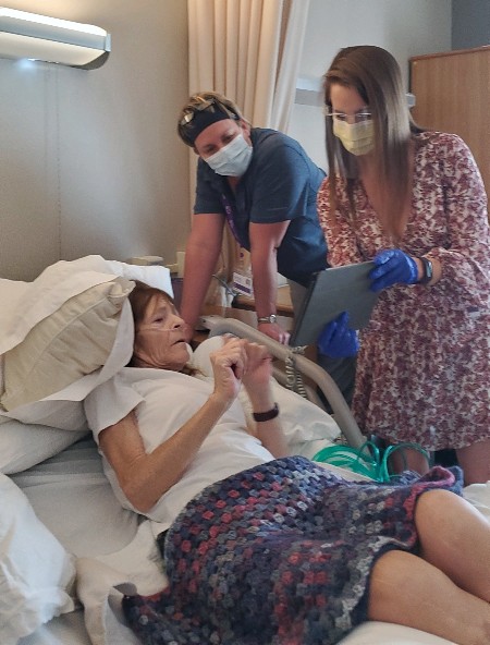 The team at Nancy's bedside showing her how the virtual reality experience works