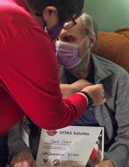 VITAS Admission Liaison Carole Quackenbush places a pin on veteran David Cornett's lapel