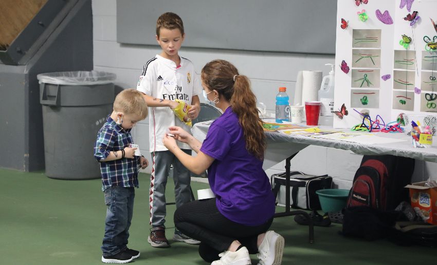 A VITAS team member greets two children who attended the event