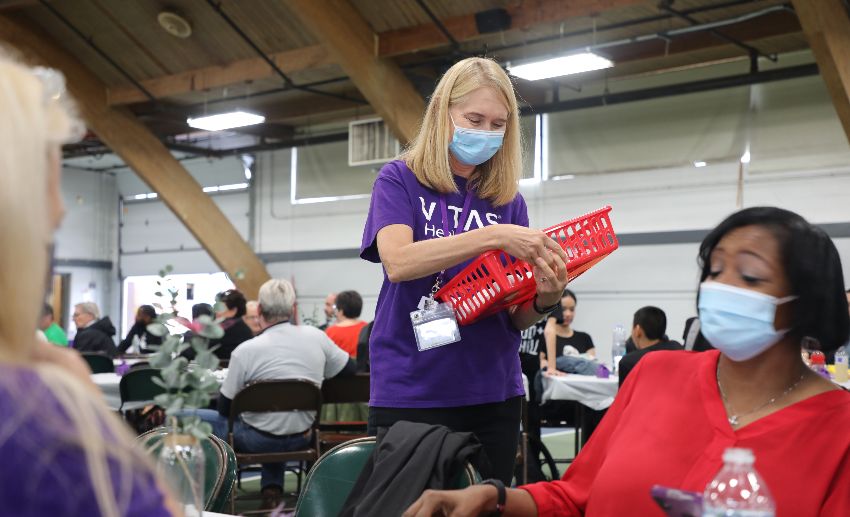 A VITAS team member passes out supplies