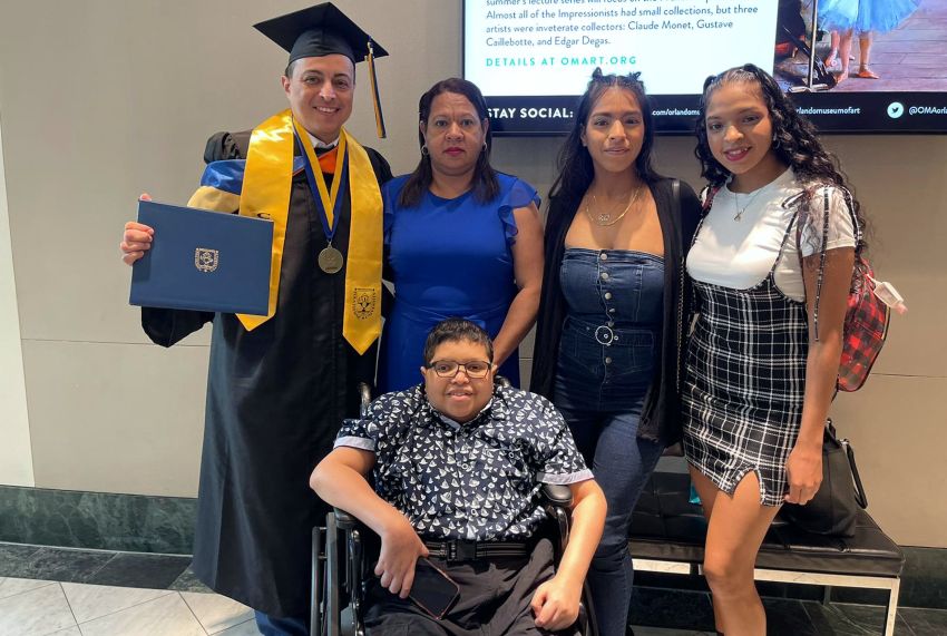 Abraham with his family. His father, in cap and gown, holds his high school diploma.