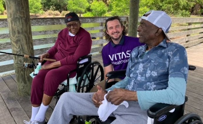 JC Payne and his wife at the fishing dock, both are smiling and talking with one of the VITAS team members