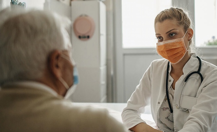 A physician talks to a patient in her office