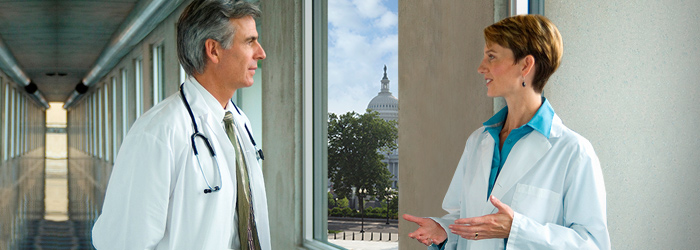 Two doctors speaking to each other in hallway