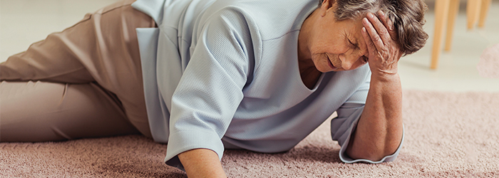 Woman lying on the ground rubbing her head