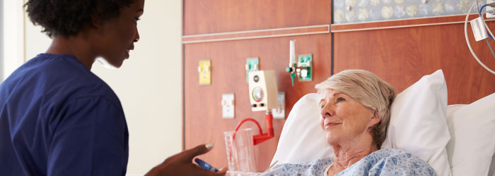 Caretaker talks to bedridden patient