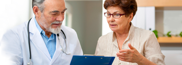 Doctor showing woman information on clipboard
