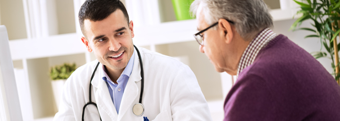 Male doctor smiles at man with glasses