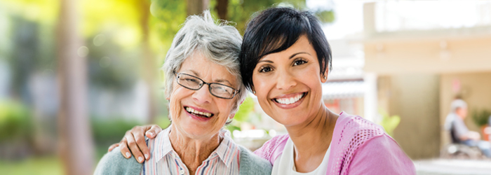 Two women smiling and embracing one another