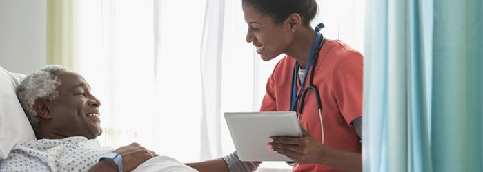 Hospice caretake with clipbaord comforting patient