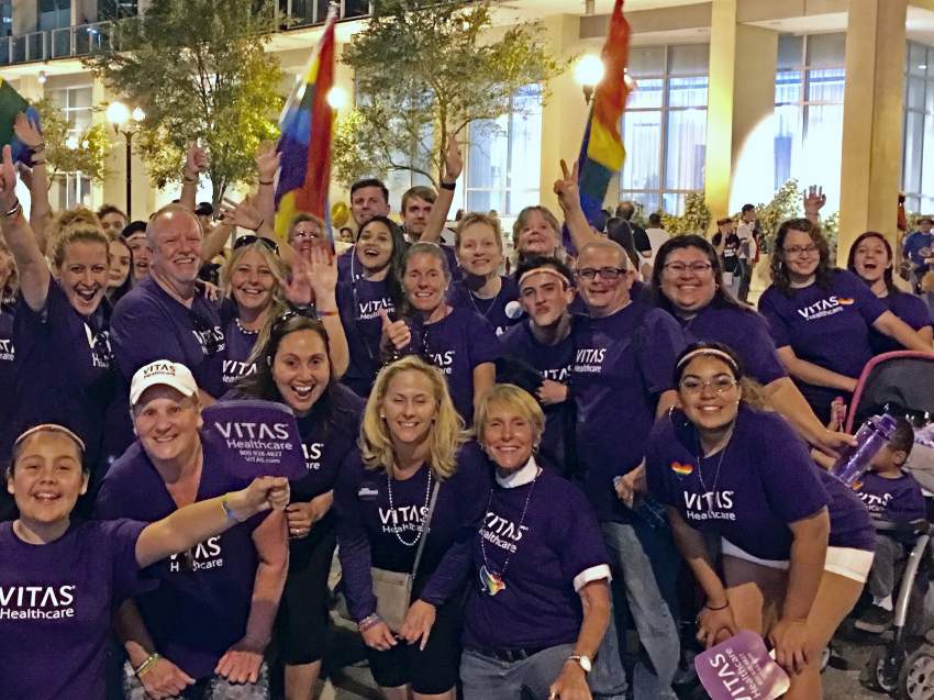 A group of VITAS employees with rainbow Pride flags