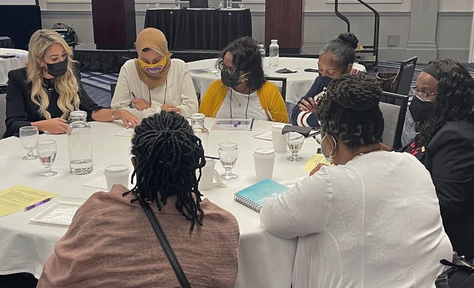 A group gathered at a table in at the National Black Nurses Association Conference reviewing the educational materials