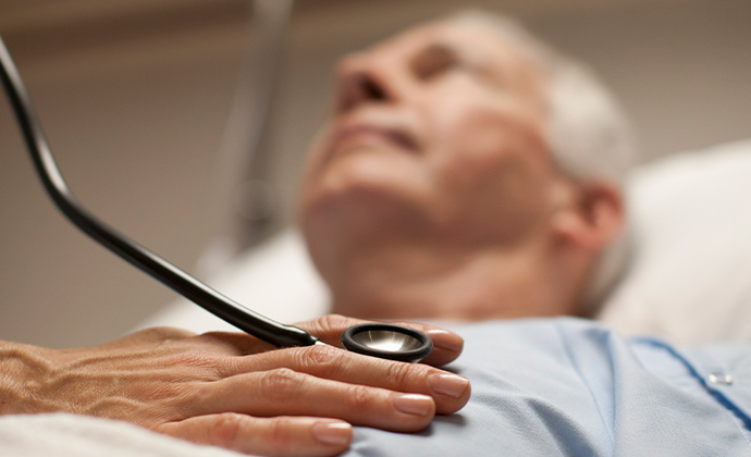 Un médico sostiene un estetoscopio sobre el pecho de un paciente