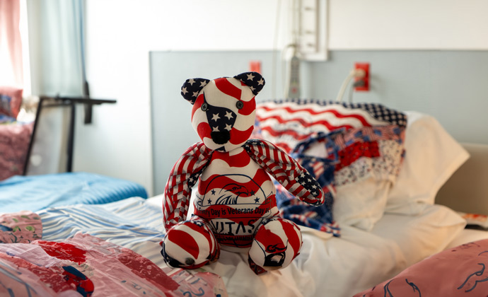 A teddy bear made from an American flag-patterned VITAS shirt.