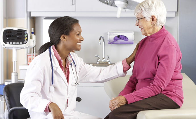 Una médica habla con una paciente en un consultorio