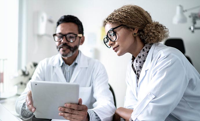 Dos médicos leen información en la misma tablet.