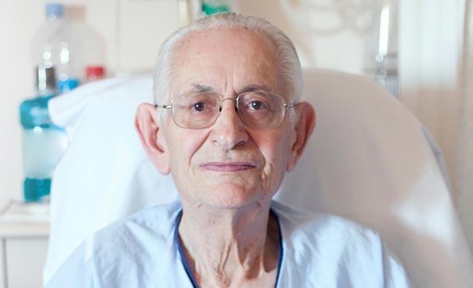 Un hombre mayor con una bata de hospital.